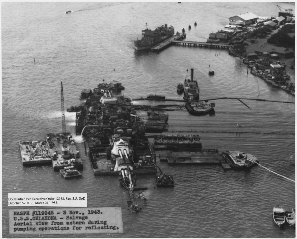 USS Oklahoma after being successfully righted, now undergoing pumping operations.